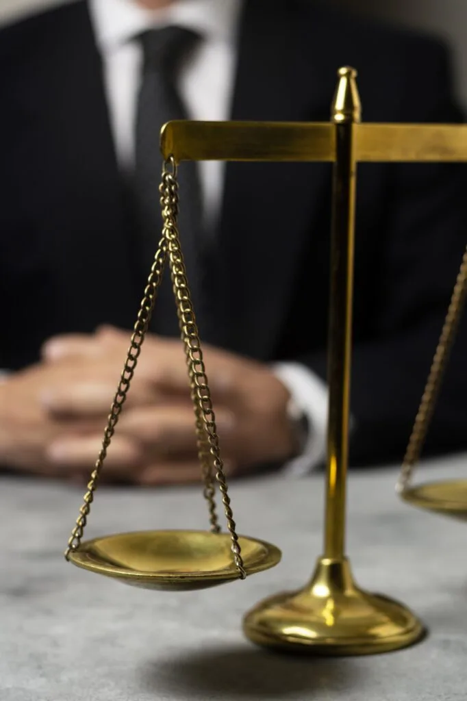 Justica lei balanca exigencia de visto Políticas de exigência de visto: balança da justiça em primeiro plano, com homem de terno ao fundo representando a autoridade na definição de