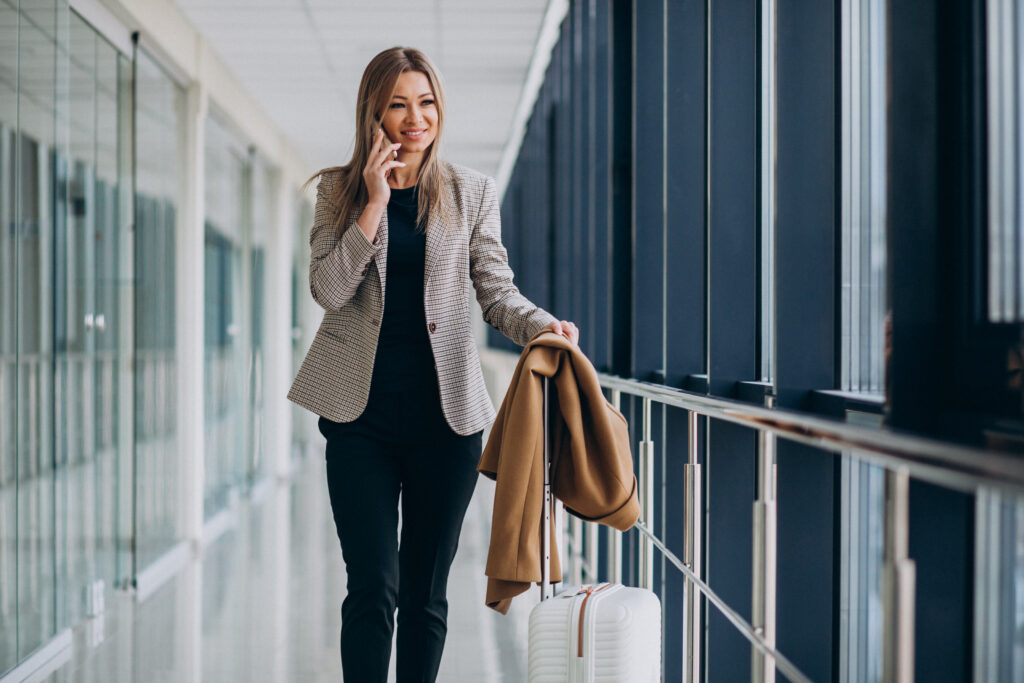Business woman terminal with travel bag talking phone